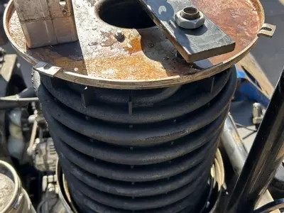 Lifting damaged heating coil out of Nilfisk Contractor diesel pressure washer boiler during repair.